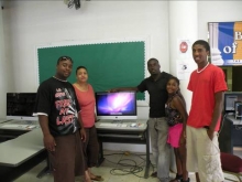 Steve Thigpen and visitors pose in front of the library’s new computer