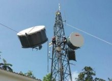 Workers install broadband equipment on a tower in Cayey, Puerto Rico.