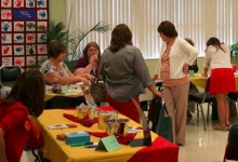 Library patrons walk from table to table at a job fair.